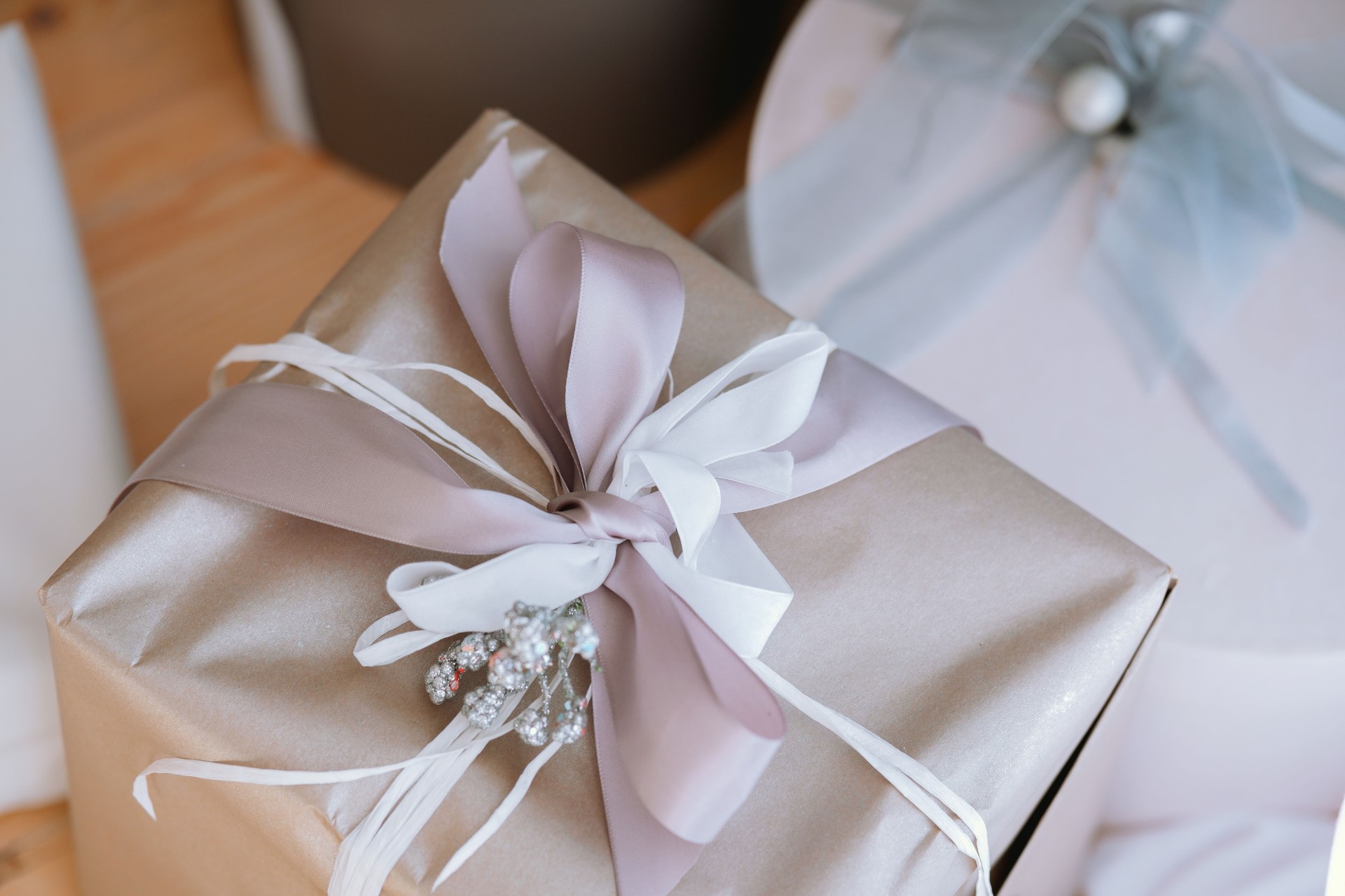 Elegant gift wrapped in silver paper with decorative ribbon and embellishments