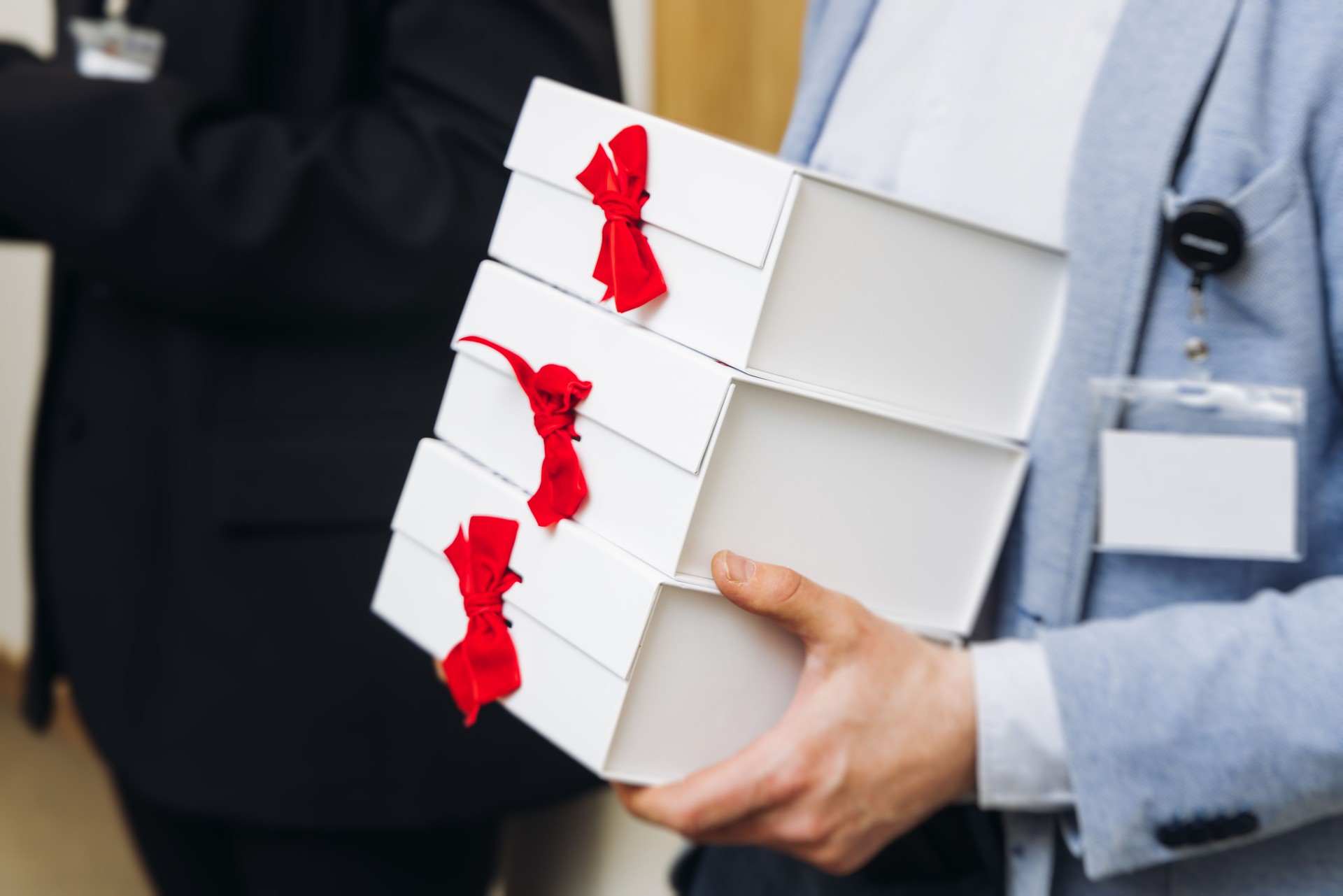 Corporate gifts and souvenirs presentation for company employees, gift bag package for conference participants before start, gift giving at office work, white and blue paper bags, New Year Christmas
